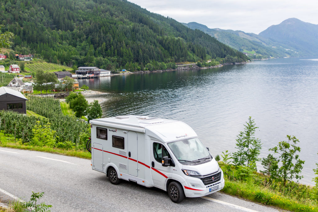 Wohnmobil am Straßenrand umgeben von Obstplantagen